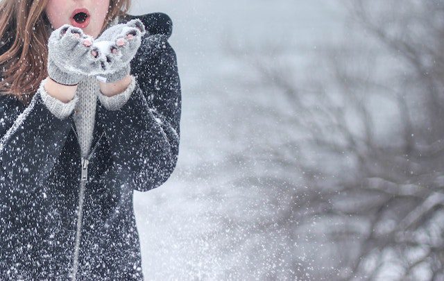 A lady cupping snow in her hands      