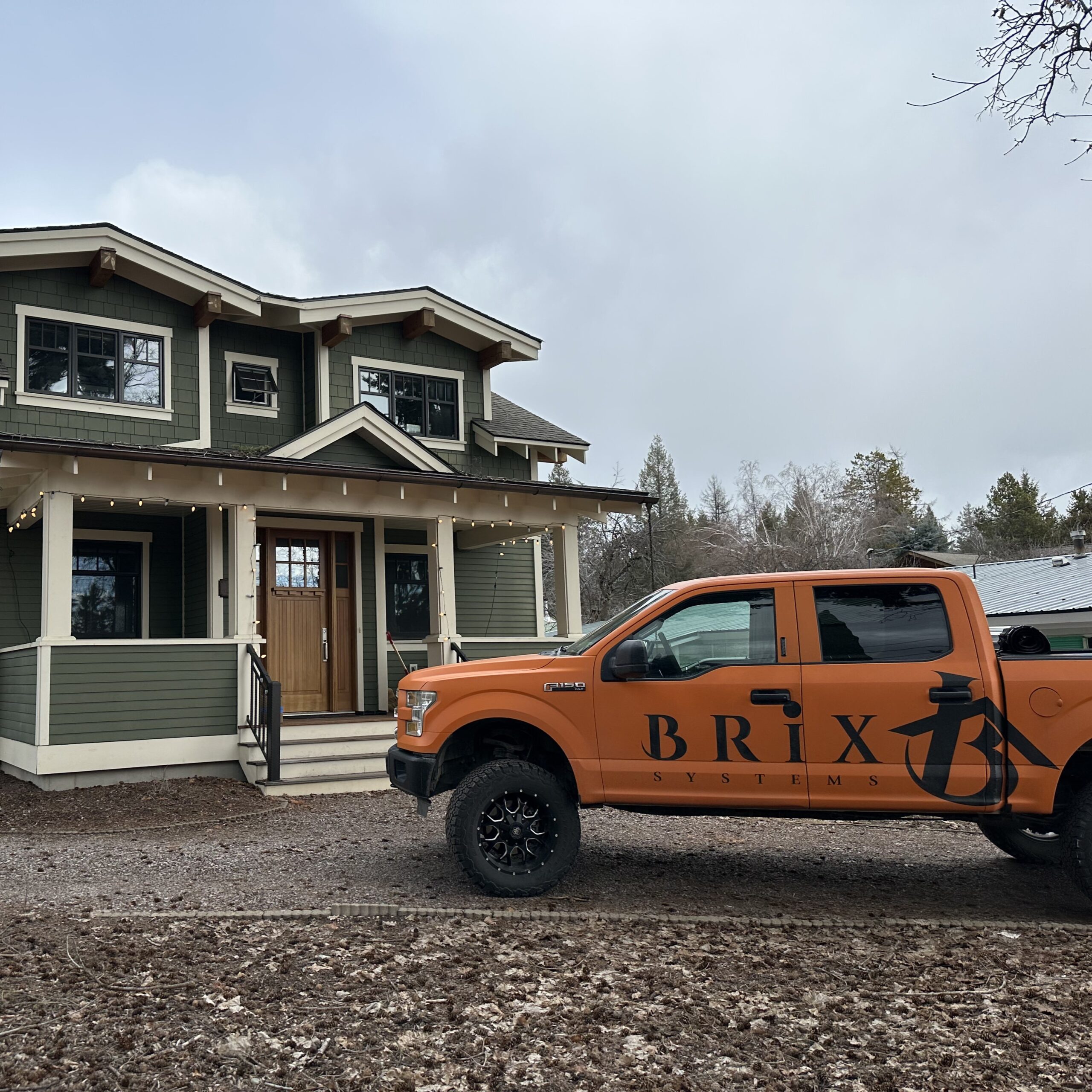 an orange truck in front of a green house