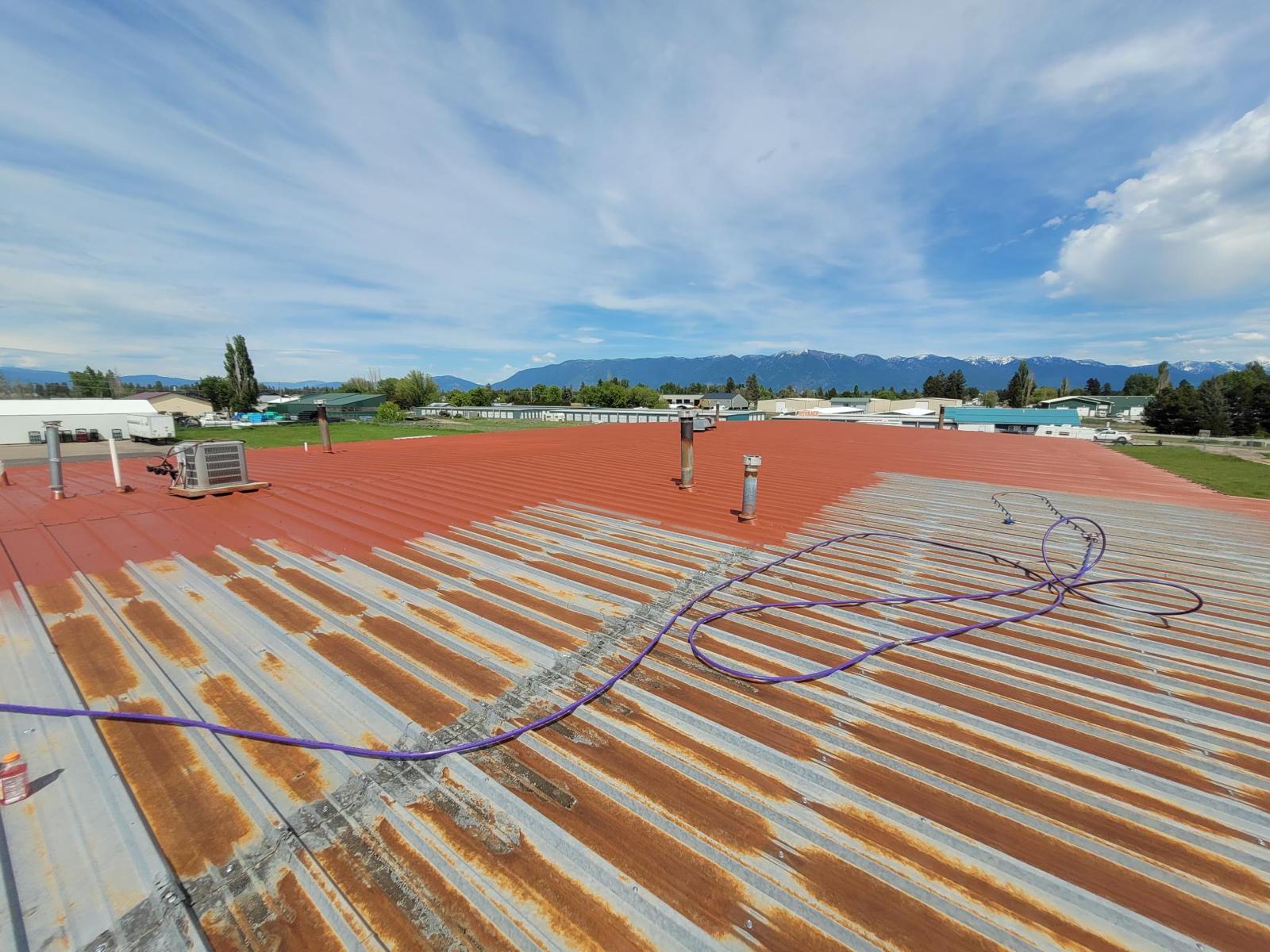 A Metal Roof getting fluid applied roofing protective coating installed