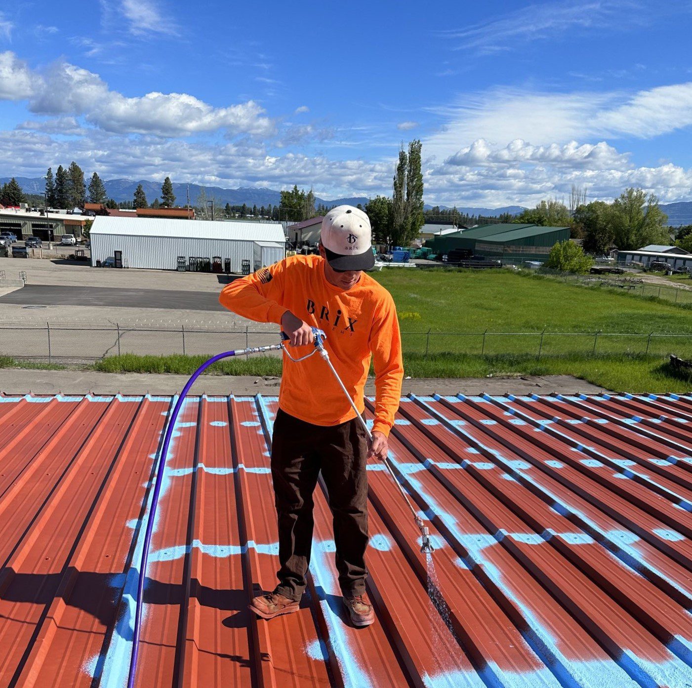 Roofer Installing Fluid Applied Roofing on A Metal Roof
